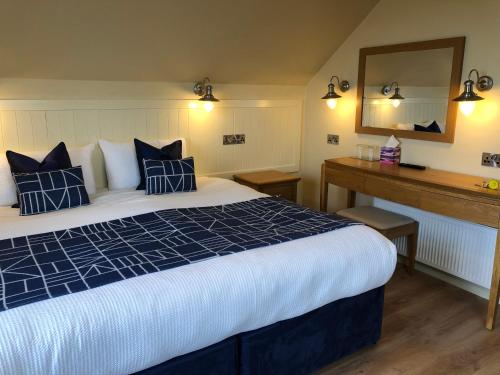 a hotel room with a large bed and a mirror at Teach Cruachan Large-Group Holiday Home in Dooagh