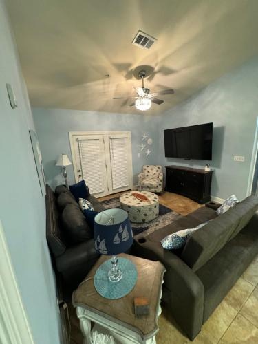a living room with a couch and a tv at Park Avenue Beauty in Foley