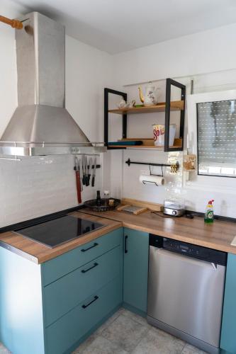 a kitchen with blue cabinets and a sink and a stove at Cookoo Villas in Kriopigi