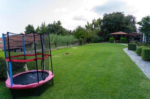 a playground with a trampoline in a yard at Cookoo Villas in Kriopigi
