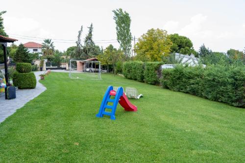 a playground with a slide in a yard at Cookoo Villas in Kriopigi