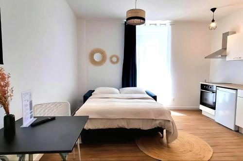 une chambre avec un lit et un bureau dans l'établissement Studio Flaubert lumineux tout confort, à Châteauroux
