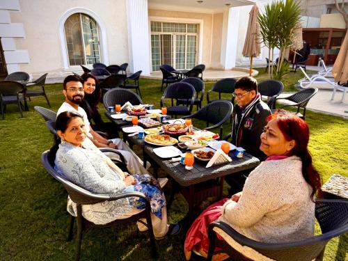 a group of people sitting around a table eating food at Giza Palace Pyramids View in Cairo
