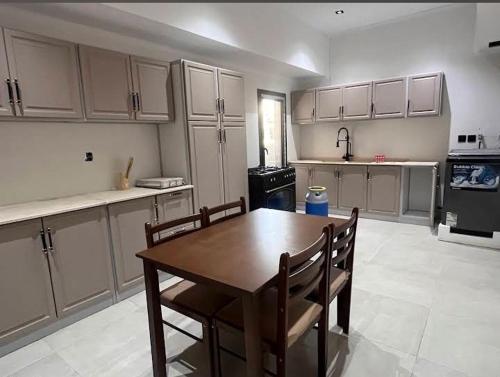 a kitchen with a wooden table and chairs in it at الريمية in Al Madinah