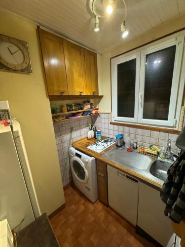 une cuisine avec un évier et une machine à laver dans l'établissement Joli deux pièces near Eiffel Tower, à Paris
