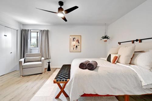a white bedroom with a bed and a ceiling fan at Artist Retreat by SoCo - Sleeps 4 - Free Parking in Austin