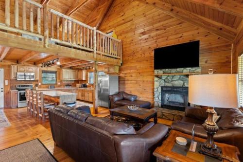 a living room with leather furniture and a fireplace at Biggie Cabin in Stanton