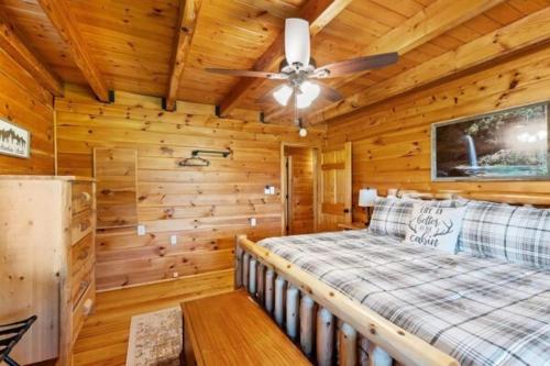 a log cabin bedroom with a bed and a ceiling fan at Biggie Cabin in Stanton