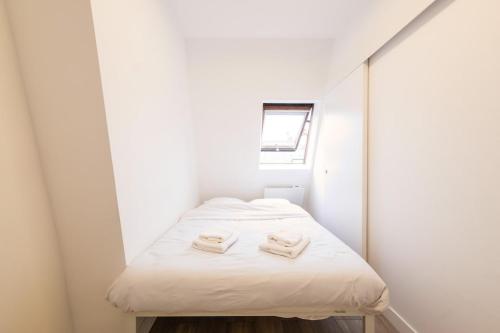 - une petite chambre avec un lit dans un dortoir blanc dans l'établissement Beautiful Studio Trudaine-Marguerite, à Paris