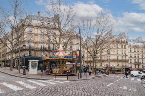 une rue avec un carrousel devant un bâtiment dans l'établissement Beautiful Studio Trudaine-Marguerite, à Paris