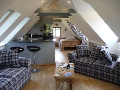 a living room with two couches and a table at Oakwrights in Terling