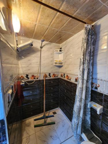 a bathroom with a shower and a black tile wall at Quadra Sphere rooftop in Tamraght Ouzdar