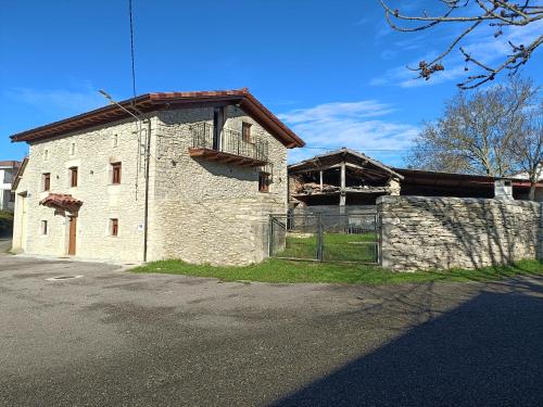 an old stone building on the side of a street at Casa Rural El Pinche in Quincoces de Yuso