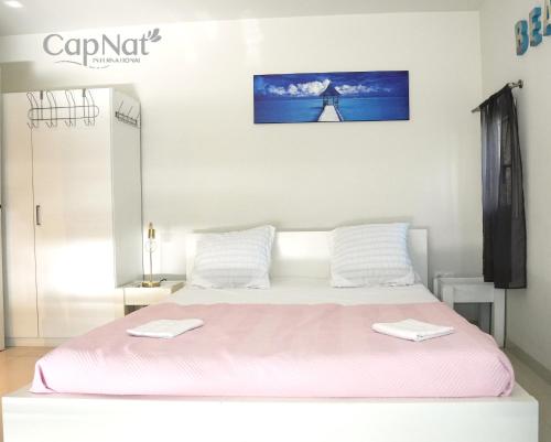 - un lit blanc avec 2 serviettes blanches dans l'établissement CapNat - Village Naturiste - Port Nature - Villa Pamela, au Cap d'Agde