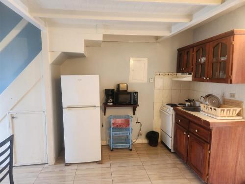 a kitchen with a white refrigerator and a microwave at Dunn's Apartments at Sandcastles in Ocho Rios