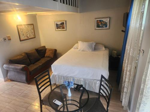 a small bedroom with a bed and a couch at Dunn's Apartments at Sandcastles in Ocho Rios