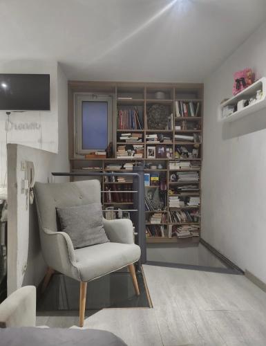 un salon avec une chaise et une télévision dans l'établissement Strasbourg centre proche gare, à Strasbourg