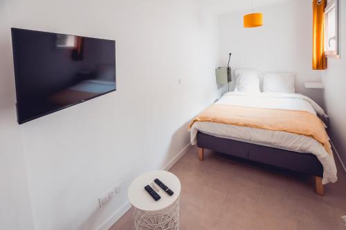 a bedroom with a bed and a table and a tv at Grand studio avec Jardin, Parking gratuit in Châteauroux