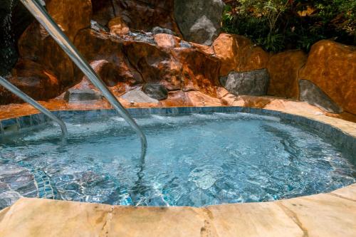 a hot tub in a pool with a waterfall at Hotel San Bada Resort & Spa in Manuel Antonio