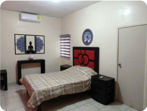 a bedroom with a bed and a clock on the wall at Cómodos cuartos para tu economia in Mazatlán