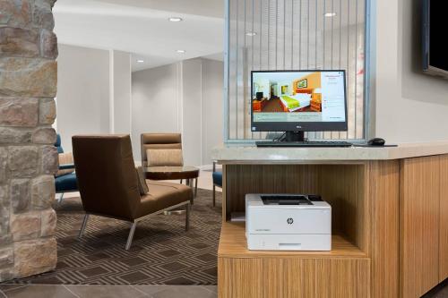 a waiting room with a computer monitor and a chair at TownePlace Suites Boone in Boone