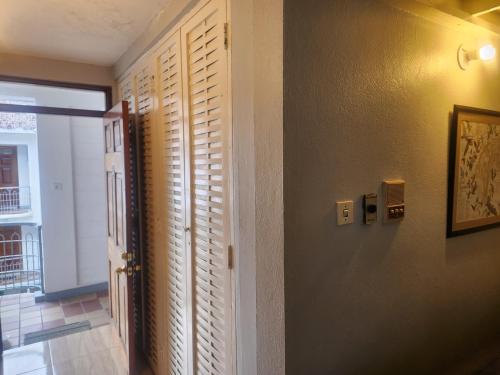 a hallway with wooden shutters and a door to a room at Dunn's Apartments at Sandcastles in Ocho Rios