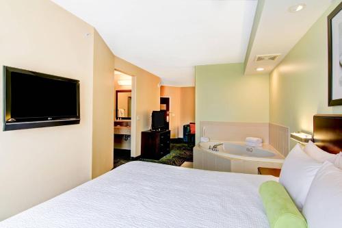 a hotel room with a bed and a bath tub at SpringHill Suites Erie in Erie