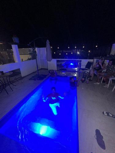 a man in a swimming pool at night at HOMESTYLE HOSTEL - 18-36yrs in Caloundra