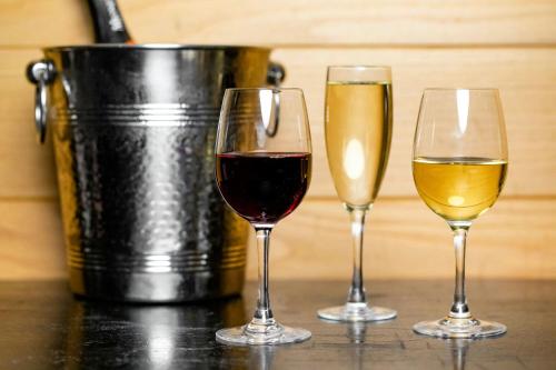 three glasses of wine on a table with a bucket at The Westin Oaks Houston at the Galleria in Houston