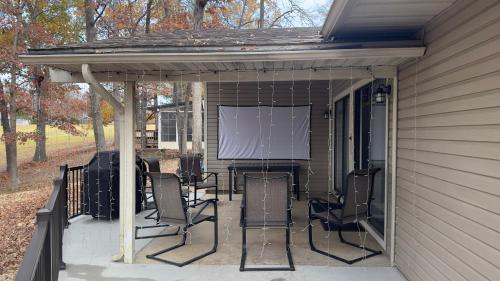 a screened in porch with chairs and a screen at No Putts Given. Cozy home on Par 4, free Golf Cart and Pool access in Osage Beach