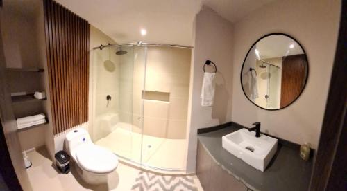 a bathroom with a shower and a toilet and a sink at Santorini Apartamentos Amoblados in Pereira