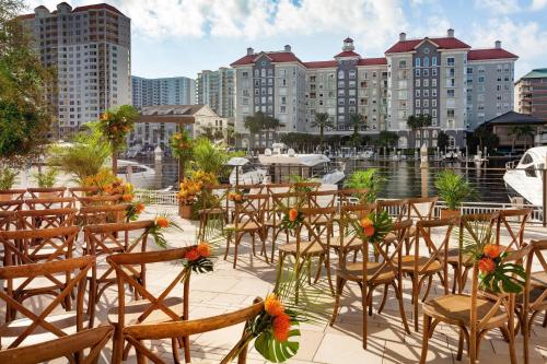 a row of tables and chairs with flowers on them at Tampa Marriott Water Street in Tampa