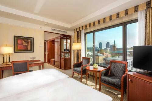ein Hotelzimmer mit einem Bett und einem großen Fenster in der Unterkunft JW Marriott Hotel Berlin in Berlin