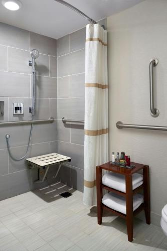 a bathroom with a shower and a toilet and a table at Marriott Tampa Westshore in Tampa