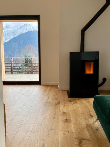 Cette chambre dispose d'une cheminée et offre une vue sur la montagne. dans l'établissement Symphonie des Cimes - rénové entièrement 2024, à Passy