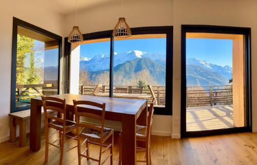 - une salle à manger avec une table et une vue sur les montagnes dans l'établissement Symphonie des Cimes - rénové entièrement 2024, à Passy