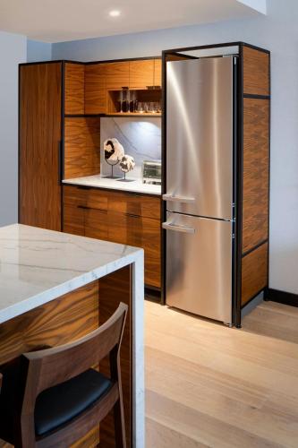 a stainless steel refrigerator in a kitchen with wooden cabinets at The Westin Houston Medical Center - Museum District in Houston
