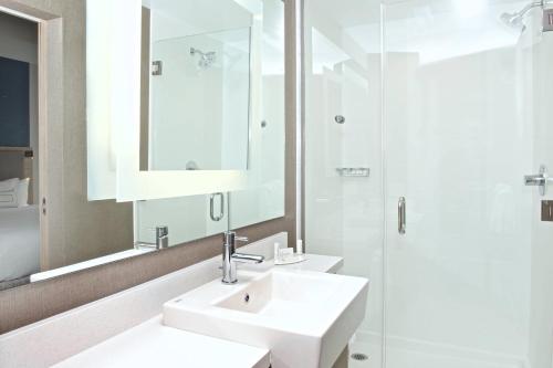 a white bathroom with a sink and a shower at SpringHill Suites by Marriott Seattle Issaquah in Issaquah