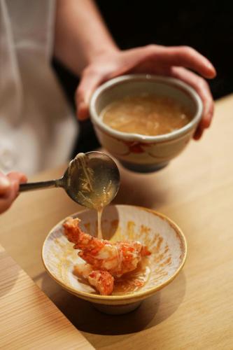 a person with a spoon and a bowl of soup at Sheraton Grand Taipei Hotel in Taipei