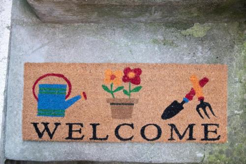 a welcome sign with a person and flowers on it at To Be Home in Bomarzo