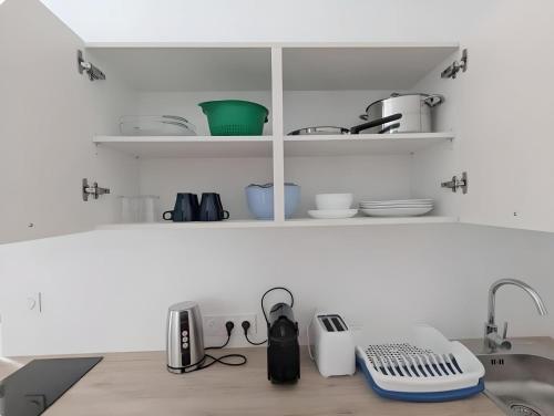 - un comptoir de cuisine avec vaisselle et appareils sur étagères dans l'établissement Grand studio avec Jardin, Parking gratuit, à Châteauroux