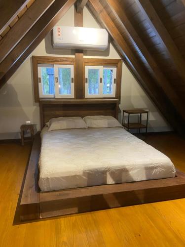 a bedroom with a large bed in a attic at Cabana Encantada in Garopaba