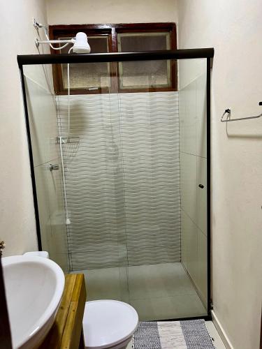 a bathroom with a shower and a toilet and a sink at Chalé nas Árvores in São Francisco Xavier