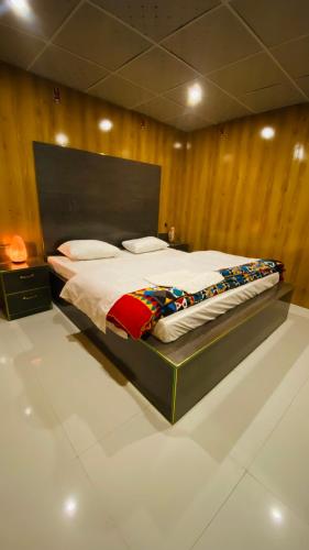 a large bed in a room with wooden walls at Astore Oasis Resort Gorikote in Kine Dās