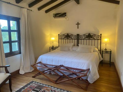 a bedroom with a bed and a cross on the wall at El Palomar casa de campo in Churqui Cañada