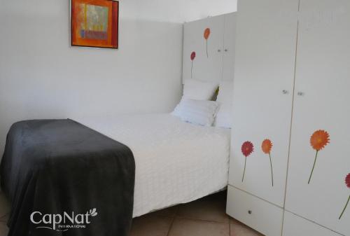 une chambre avec un lit avec des fleurs peintes sur le mur dans l'établissement CapNat - Village Naturiste - Port Nature - Villa Malibu, au Cap d'Agde