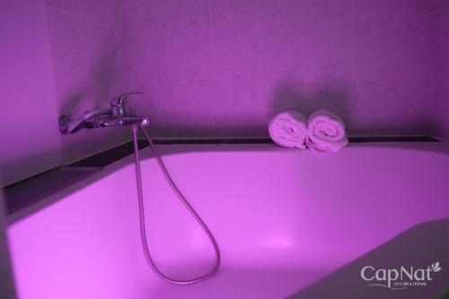une salle de bains pourpre avec douche et éclairage rose dans l'établissement CapNat - Village Naturiste - Port Nature - Villa Malibu, au Cap d'Agde