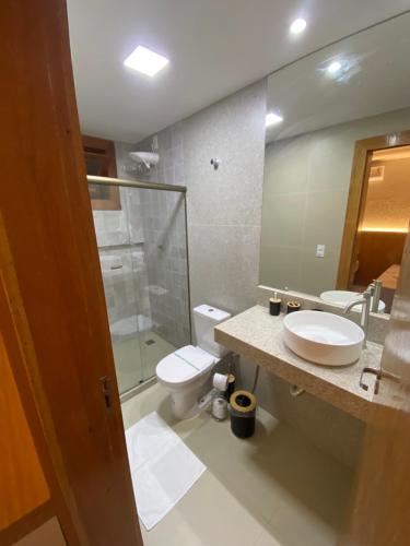 Bangalo Aconchegante - Praia Dulé ES - Suite 1 في غواراباري: حمام مع حوض ومرحاض ومرآة