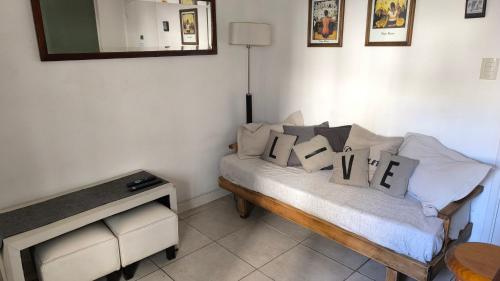 een woonkamer met een bank met kussens erop bij Depto Gascón in Mar del Plata