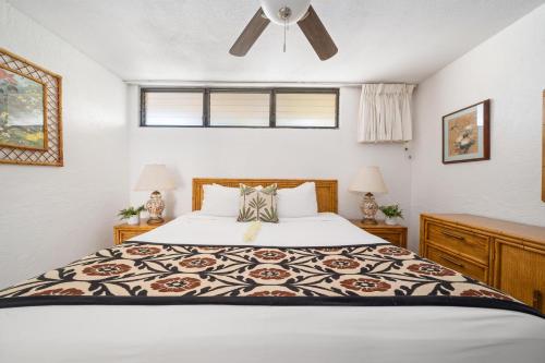 a bedroom with a bed and a ceiling fan at Papakea B201 · PK B201 Updated Condo w Ocean View in Kahana